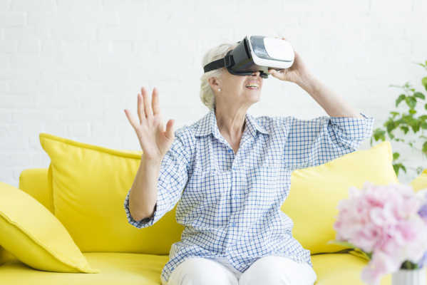 senior-woman-sitting-yellow-sofa-enjoying-virtual-reality-glasses