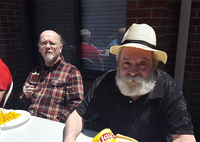 Two older male residents eating at the table